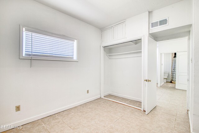 8929 Robert Dr Unit 1 & 2, El Paso, TX 79904 - unfurnished bedroom with light tile patterned flooring, baseboards, visible vents, and a closet