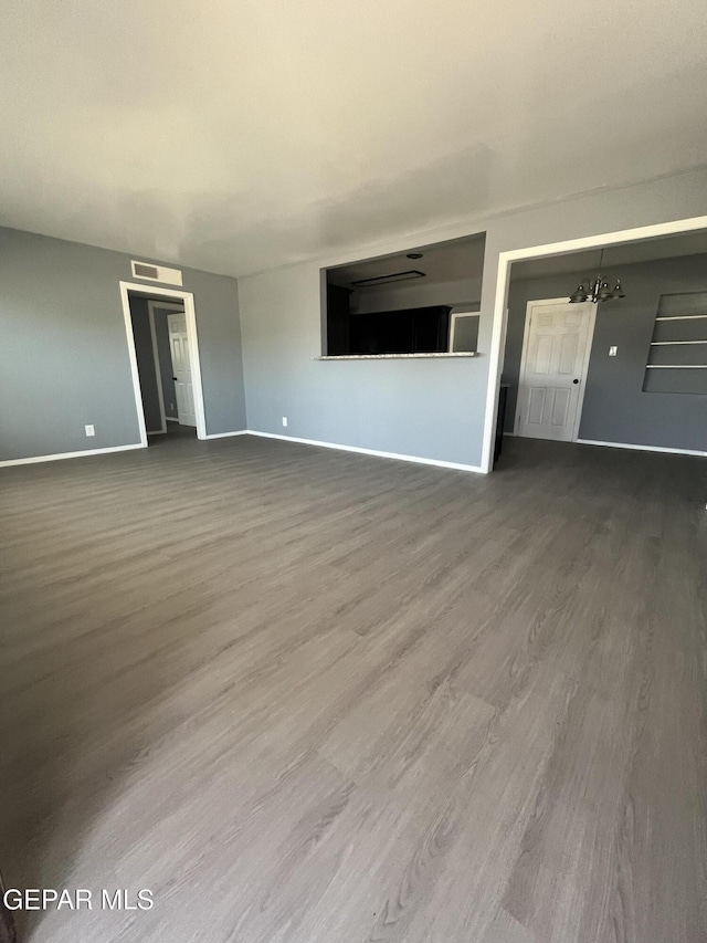 unfurnished living room featuring baseboards and wood finished floors