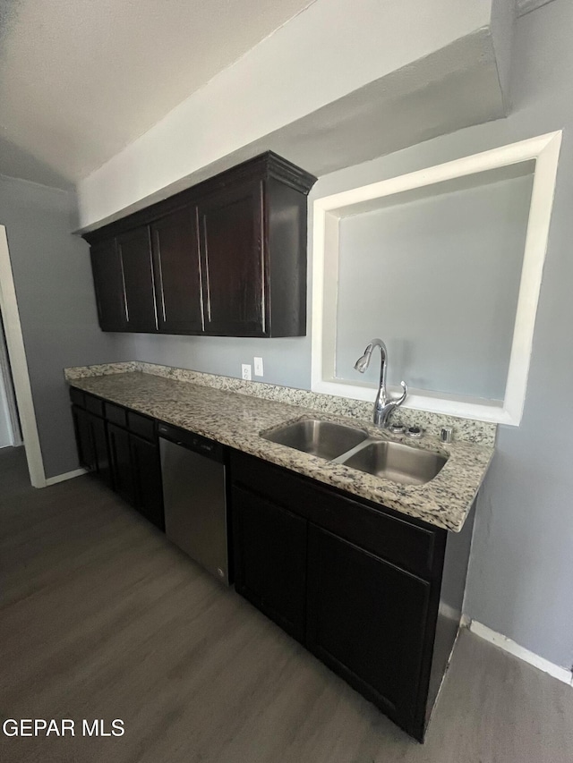 kitchen featuring wood finished floors, a sink, dishwasher, and light stone countertops