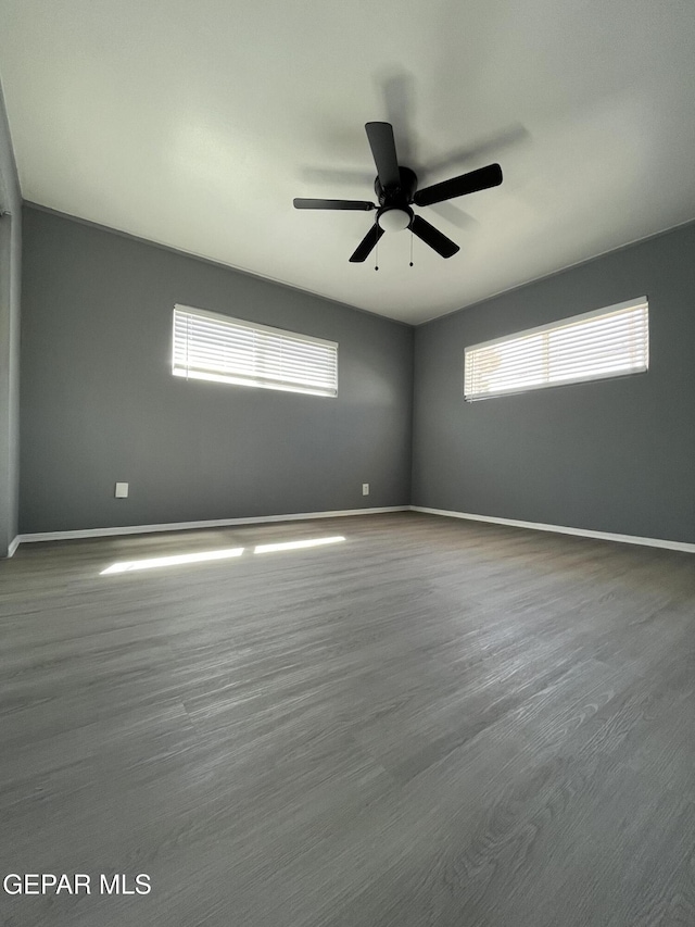 unfurnished room with baseboards, a ceiling fan, and a wealth of natural light