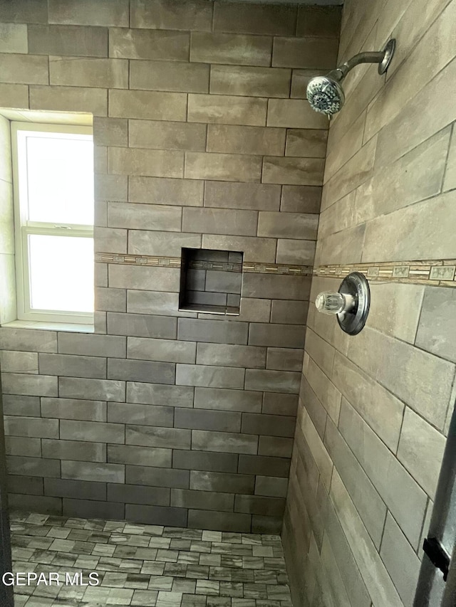 interior details with a tile shower