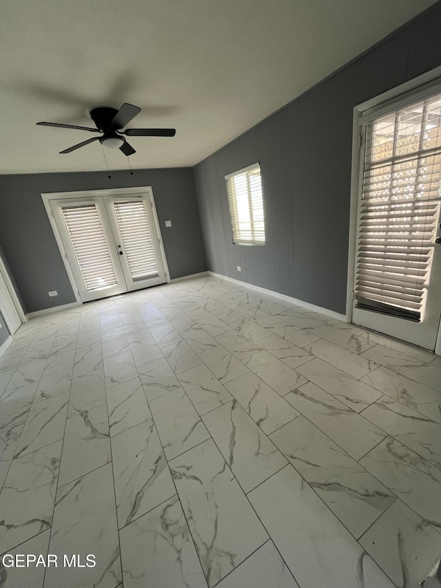 spare room featuring baseboards, a ceiling fan, and marble finish floor
