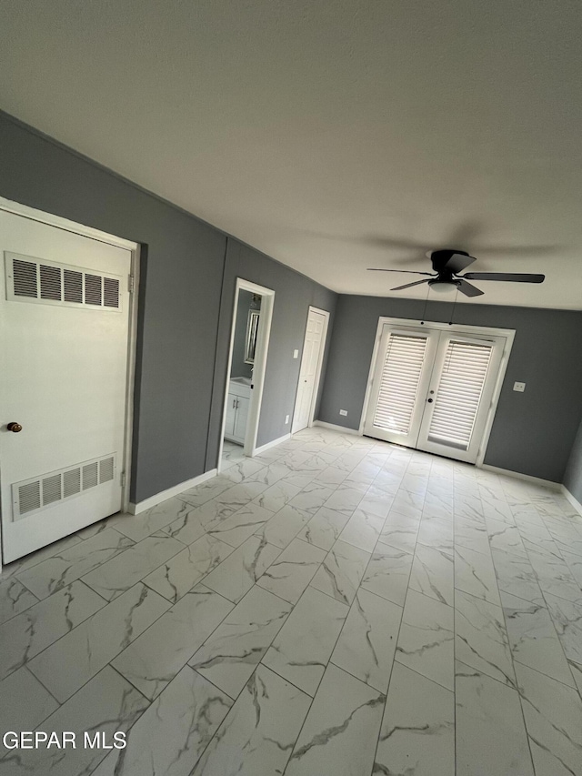 spare room with baseboards, a ceiling fan, and marble finish floor