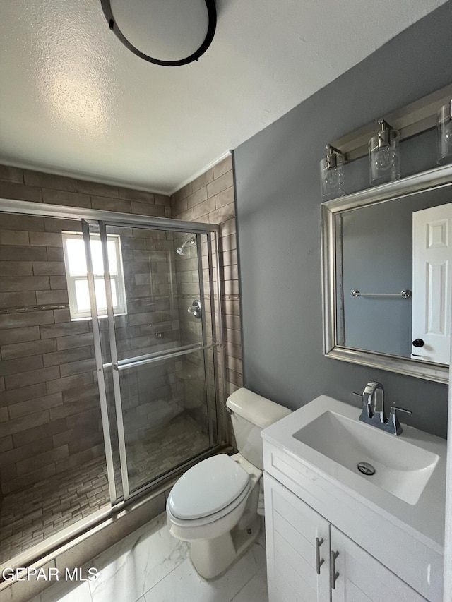 full bathroom with vanity, a stall shower, toilet, and marble finish floor