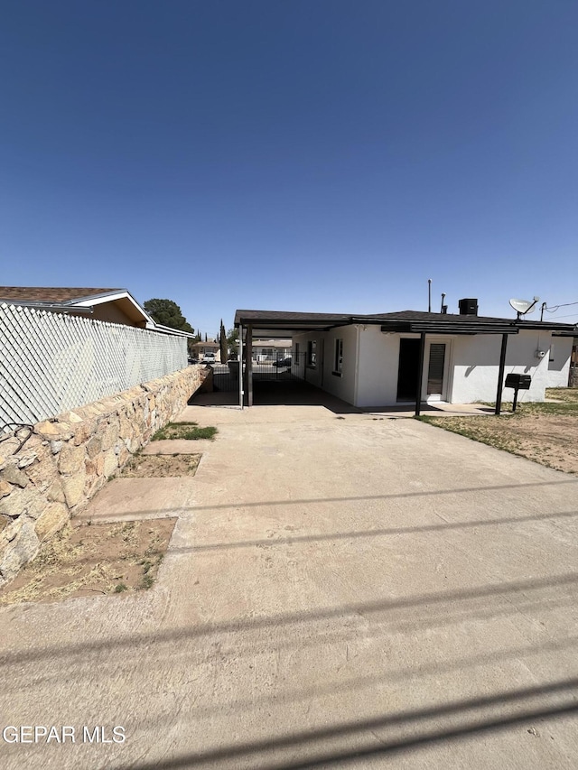 view of front of property featuring fence, driveway, and an attached carport