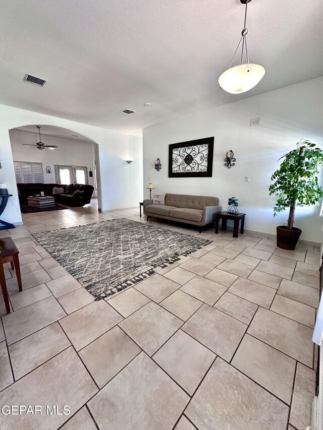 1363 Golden Trail Ln, El Paso, TX 79936 - living room with arched walkways, a ceiling fan, a textured ceiling, and light tile patterned flooring