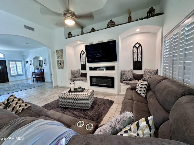 1363 Golden Trail Ln, El Paso, TX 79936 - living area featuring arched walkways, a ceiling fan, light tile patterned floors, and a glass covered fireplace