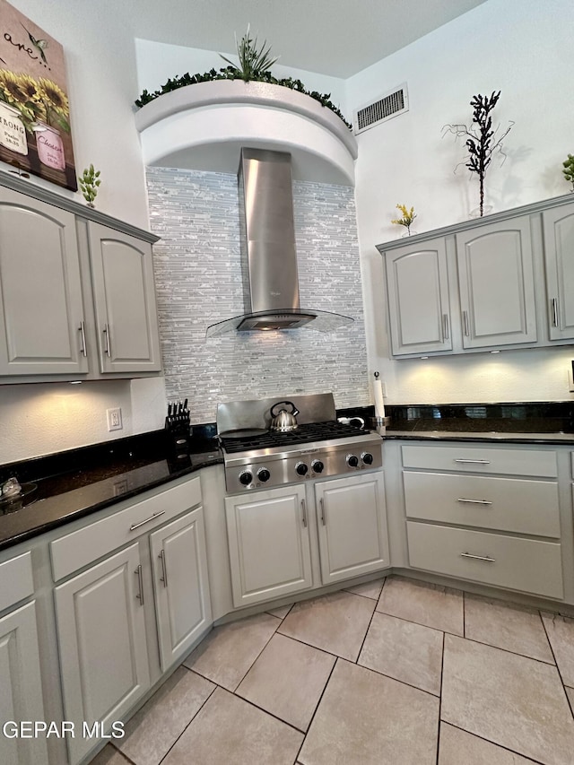 1363 Golden Trail Ln, El Paso, TX 79936 - kitchen with wall chimney exhaust hood, dark countertops, stainless steel gas cooktop, and gray cabinetry