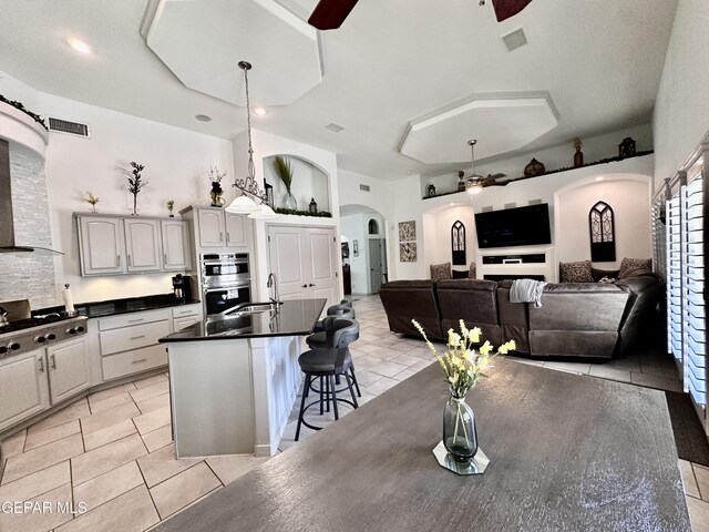 1363 Golden Trail Ln, El Paso, TX 79936 - kitchen with arched walkways, dark countertops, a ceiling fan, appliances with stainless steel finishes, and light tile patterned floors