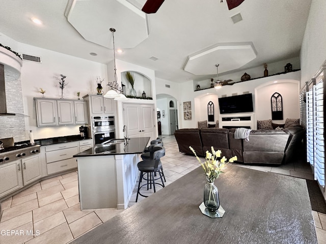 1363 Golden Trail Ln, El Paso, TX 79936 - kitchen with arched walkways, dark countertops, a ceiling fan, appliances with stainless steel finishes, and light tile patterned floors