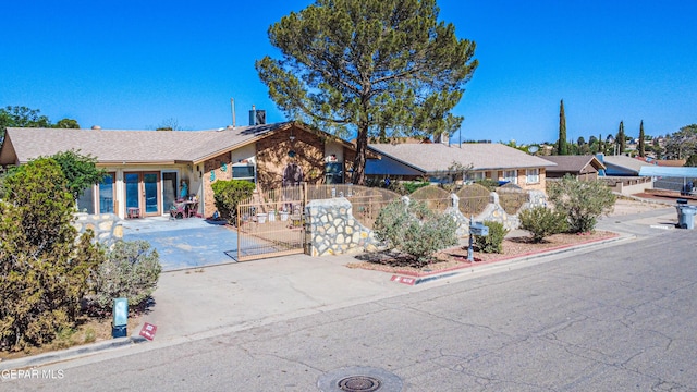 ranch-style home with fence and a gate