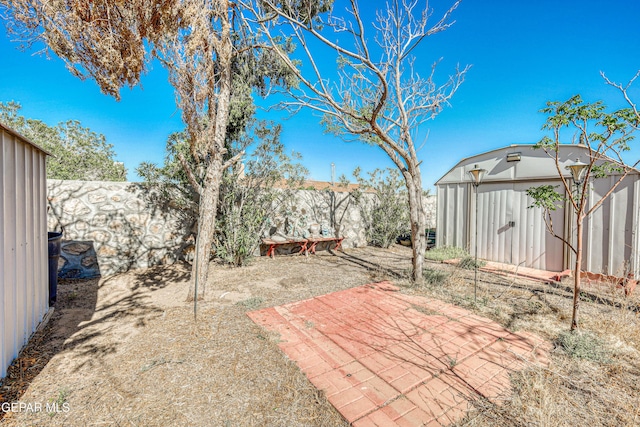 view of patio featuring an outbuilding, a fenced backyard, and a storage shed