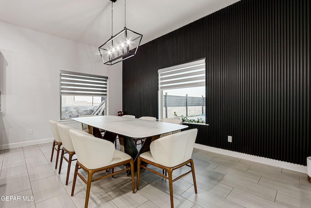 dining room featuring an inviting chandelier, baseboards, and a healthy amount of sunlight