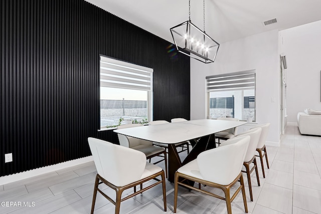dining area featuring light tile patterned floors, baseboards, visible vents, and a chandelier