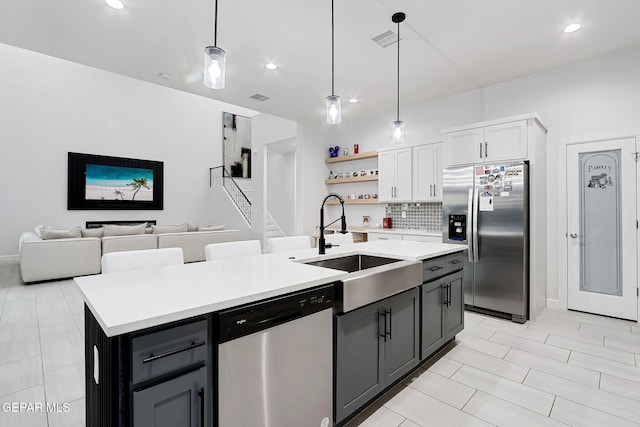 kitchen featuring light countertops, a sink, decorative backsplash, and stainless steel appliances