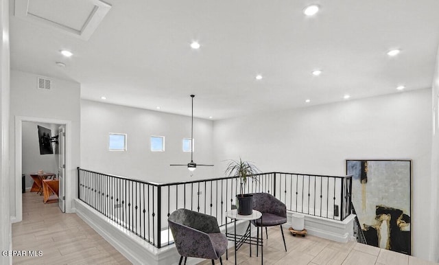 hall featuring light wood finished floors, recessed lighting, and visible vents