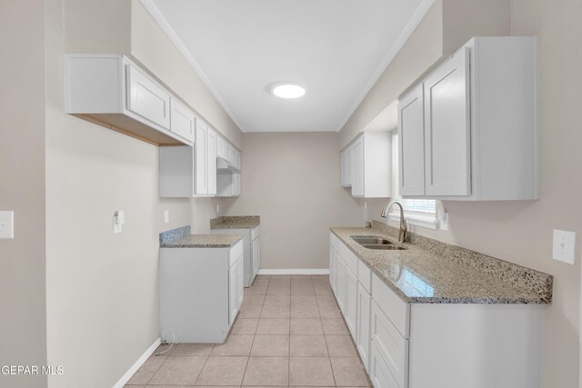 10601 Teresa Pl, El Paso, TX 79924 - kitchen featuring a sink, baseboards, light stone counters, and white cabinets