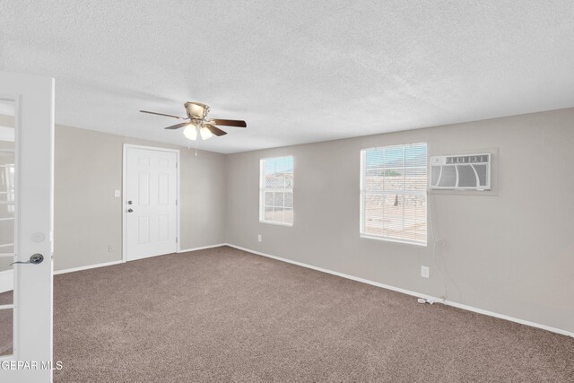 10601 Teresa Pl, El Paso, TX 79924 - carpeted empty room with a wall mounted AC, a ceiling fan, baseboards, and a textured ceiling