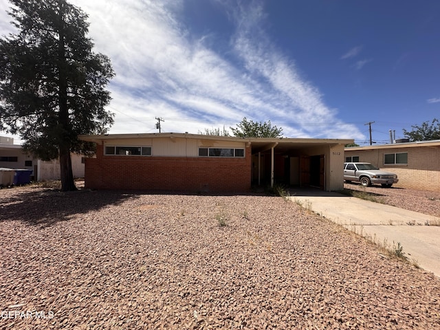 single story home with an attached carport, driveway, and brick siding