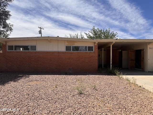 single story home with brick siding, driveway, and an attached carport