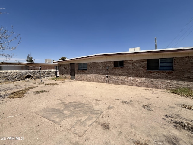 rear view of house featuring brick siding