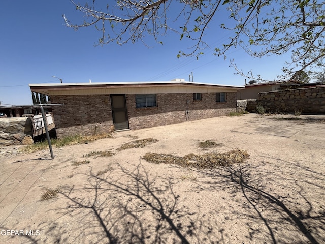 back of property featuring brick siding