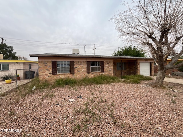 single story home with brick siding, fence, and a garage