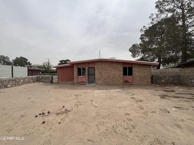 back of property with fence and brick siding