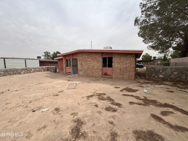 back of property with fence and brick siding