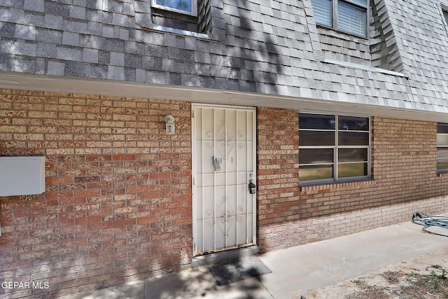 view of exterior entry featuring brick siding
