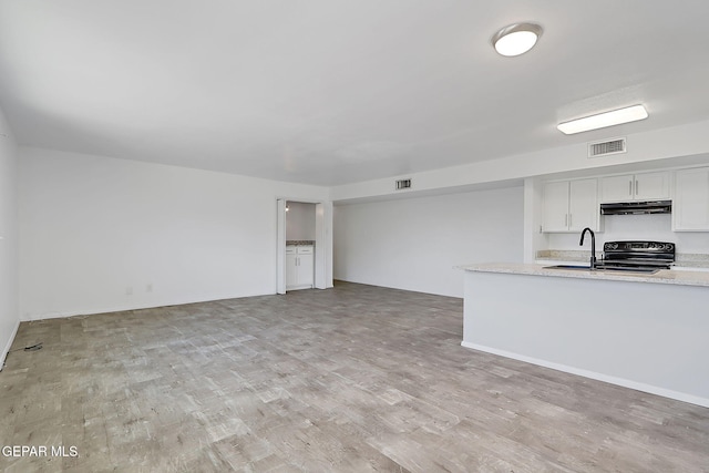 unfurnished living room featuring light wood finished floors and visible vents