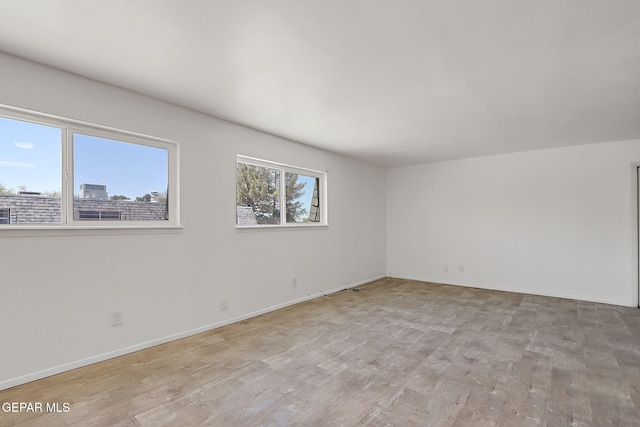 spare room with light wood-style floors and baseboards