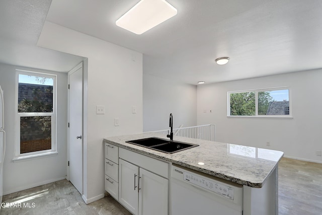 kitchen with a sink, plenty of natural light, light wood-style flooring, and dishwasher