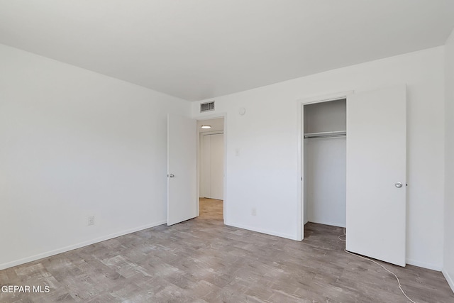 unfurnished bedroom featuring baseboards, visible vents, and a closet