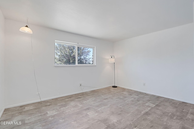 empty room with baseboards and wood finished floors