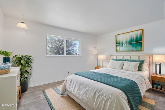 bedroom with baseboards and light wood-type flooring