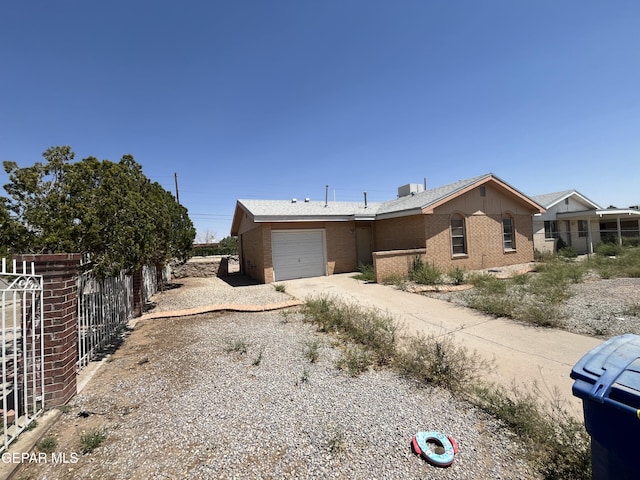 ranch-style house with brick siding, dirt driveway, and fence
