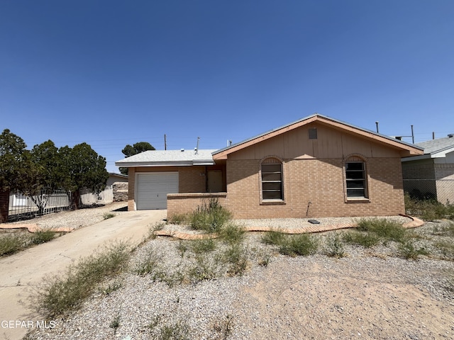 ranch-style house featuring a garage, fence, driveway, and brick siding