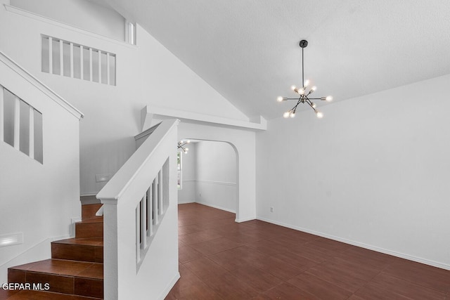 stairs with high vaulted ceiling and a chandelier