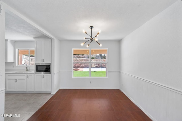 unfurnished dining area featuring a sink and a chandelier