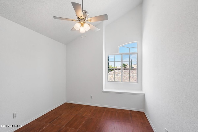 spare room featuring a ceiling fan, baseboards, dark wood finished floors, and lofted ceiling