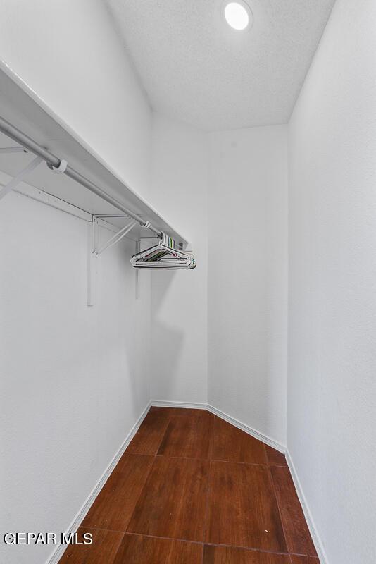 spacious closet with dark wood-style floors