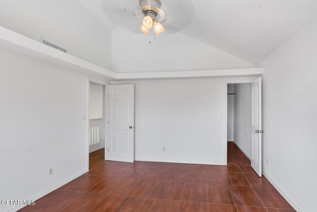 unfurnished bedroom featuring a ceiling fan, baseboards, visible vents, and vaulted ceiling