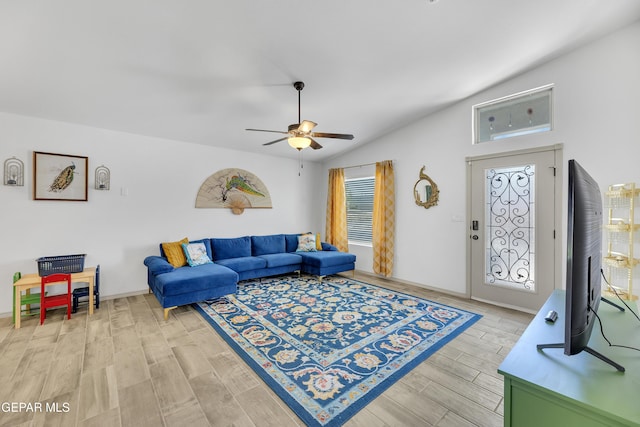 living room with ceiling fan, vaulted ceiling, light wood-type flooring, and a wealth of natural light