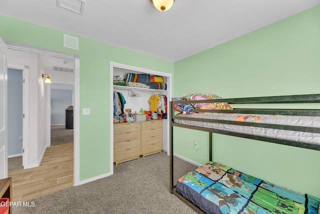 bedroom with visible vents, baseboards, and a closet