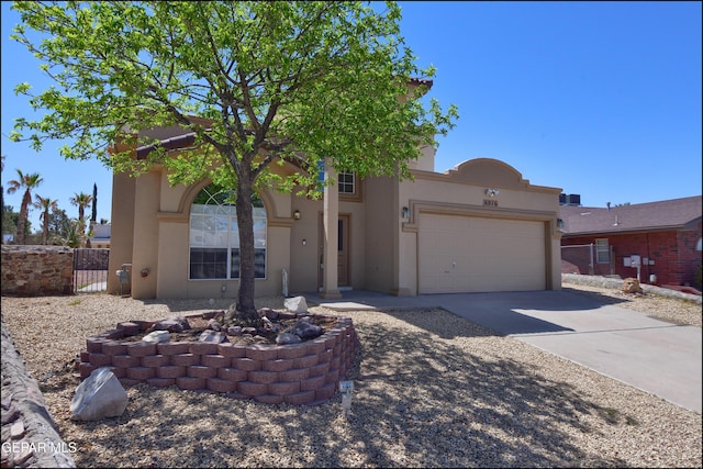 view of front of house featuring concrete driveway, an attached garage, stucco siding, and fence