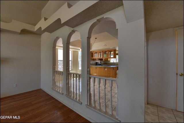 interior space featuring baseboards, arched walkways, and wood finished floors