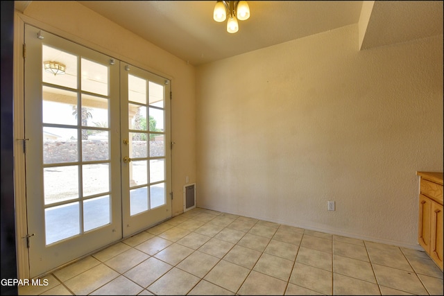 doorway with light tile patterned floors, baseboards, french doors, and plenty of natural light