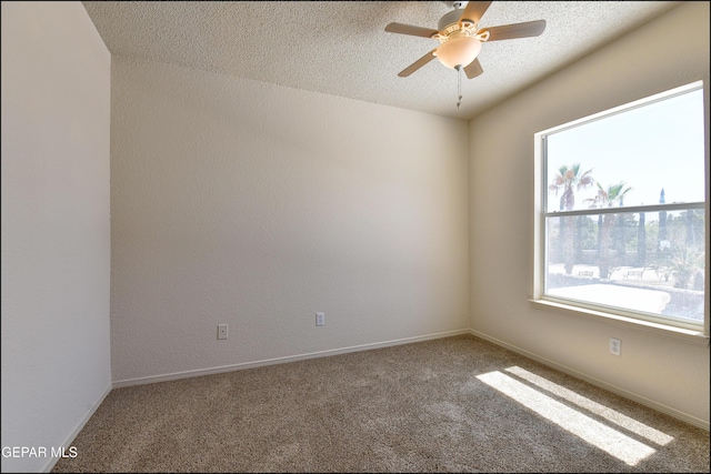 carpeted empty room featuring ceiling fan and baseboards