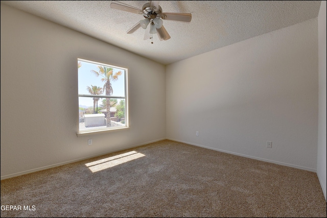 carpeted spare room featuring baseboards, ceiling fan, and a textured ceiling